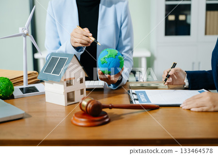 Two professionals plan global sustainability with eco housing, legal contracts, solar energy, and financial investment Two professionals plan global sustainability with eco housing, legal contracts, solar energy, and financial investment 133464578