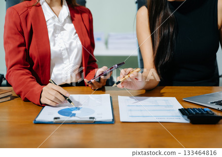 Business documents on office table with smart phone and calculator digital tablet and graph business with social network diagram and two colleagues discussing data 133464816