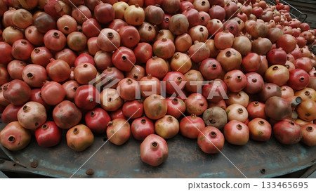 A large pile of pomegranates are stacked together ready for market sale 133465695