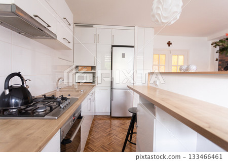 A modern kitchen that features a sleek design combined with a warm and cozy atmosphere 133466461