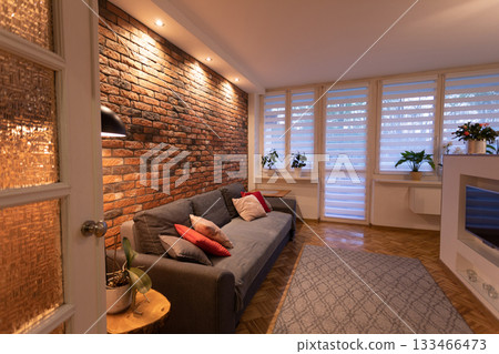 A Cozy and Modern Living Room Featuring a Stunning Brick Accent Wall that Enhances Its Charm 133466473