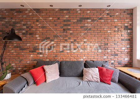 A Cozy and Inviting Living Room Featuring a Beautiful Brick Wall and a Comfortable Sofa A Cozy and Inviting Living Room Featuring a Beautiful Brick Wall and a Comfortable Sofa 133466481