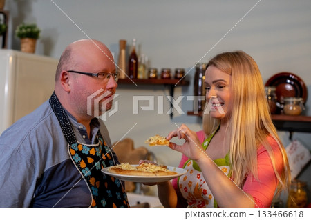 Family cooking together, Cozy setting where father and daughter share delicious pasta meal, Intimate moment of family togetherness as they savor homemade pasta in rustic Family cooking together, Cozy setting where father and daughter share delicious pasta meal, Intimate moment of family togetherness as they savor homemade pasta in rustic 133466618
