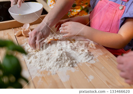 Family baking session, Children and adults kneading dough, Closeup of hands guiding dough preparation, Warm morning light highlights familial cooking bonding moments 133466620