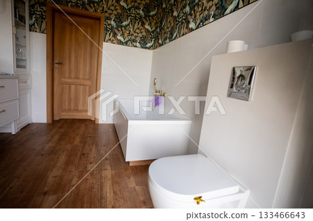 Warm family bathroom with toilet, wooden door and patterned wallpaper, soft towels and hygge textures, staged by host for welcoming guest stays and practical everyday use 133466643