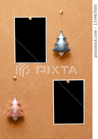 Empty photos and Christmas tree toys are pinned on a cork board. Copy space 133467600