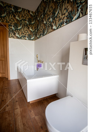 Intimate bath area with floral decor, Serene corner featuring wooden door and floral wallpaper, Comfortable bathtub nook decorated with blossoms and subdued lighting ambiance 133467655