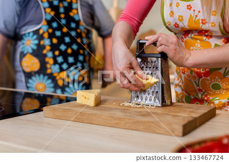 Grating Cheese in a Vibrant and Colorful Kitchen Setting for a Culinary Experience Grating Cheese in a Vibrant and Colorful Kitchen Setting for a Culinary Experience 133467724