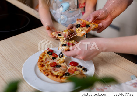Gathering and sharing a delightful pizza meal together at home with family and friends Gathering and sharing a delightful pizza meal together at home with family and friends 133467752