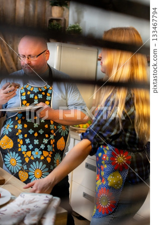 Enjoying the experience of cooking together while wearing colorful and vibrant aprons 133467794