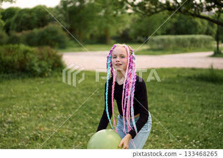 A Child Filled with Joy as They Enjoy Playtime Outdoors with a Bright Colorful Balloon A Child Filled with Joy as They Enjoy Playtime Outdoors with a Bright Colorful Balloon 133468265