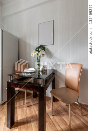 Cozy Kitchen Dining Area with Glass Table and Flowers 133469235