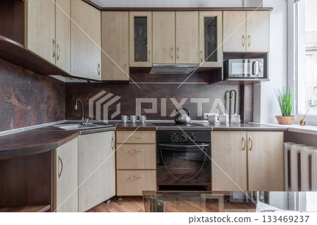 Modern Wooden Kitchen Interior with Oven and Window Light 133469237