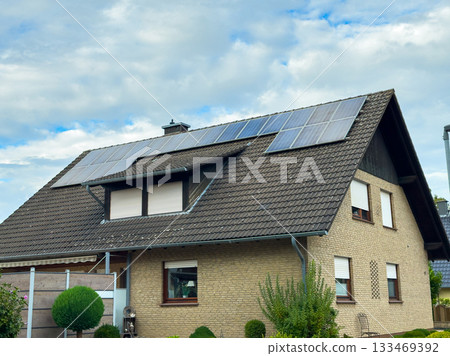 Solar panels shine on a cozy home nestled in a serene neighborhood during a bright afternoon Solar panels shine on a cozy home nestled in a serene neighborhood during a bright afternoon 133469392