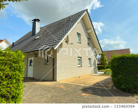 Charming suburban home with a well-kept garden and sunny atmosphere on a bright summer day Charming suburban home with a well-kept garden and sunny atmosphere on a bright summer day 133469394