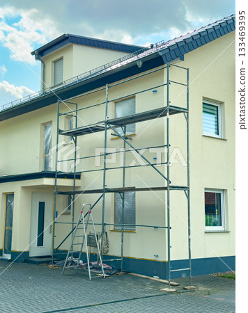 Renovation work in progress on a residential building under a bright sky in the afternoon 133469395