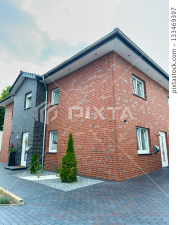 Modern brick house with stylish design and landscaped garden in a suburban neighborhood captured on a bright day 133469397