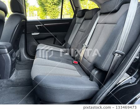 Interior of a spacious vehicle showcasing comfortable back seats and ample legroom in bright daylight, emphasizing quality and design for a relaxed ride experience 133469473