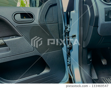 Intricate details of a car door interior showcase craftsmanship and functionality in a well-lit parking area during daylight hours 133469547
