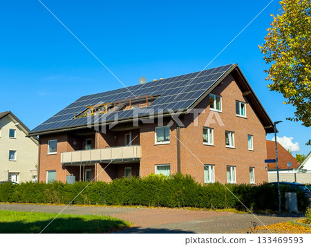 Bright autumn afternoon showcases modern home with solar panels and vibrant blue sky 133469593