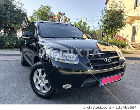 Elevating the streets in a sleek black SUV parked under a clear blue sky, showcasing a blend of style and utility on a sunny afternoon 133469694