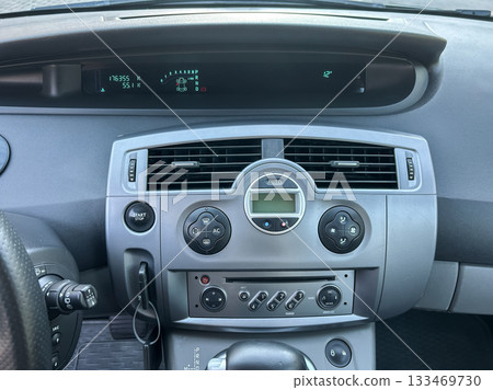 Dashboard display of a car showing the odometer reading and temperature during a sunny day drive 133469730
