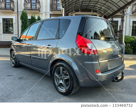 Shining grey car parked under a beautiful archway in a serene location, showcasing its sleek design and modern features during golden hour Shining grey car parked under a beautiful archway in a serene location, showcasing its sleek design and modern features during golden hour 133469732