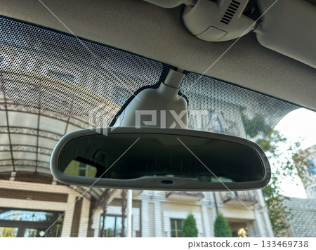 Reflections captured inside a car revealing a charming entrance of a building on a sunny day Reflections captured inside a car revealing a charming entrance of a building on a sunny day 133469738