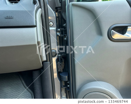 Details of a car door latch mechanism showing components in a modern vehicle parked in a driveway on a sunny day Details of a car door latch mechanism showing components in a modern vehicle parked in a driveway on a sunny day 133469744