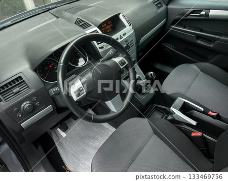 Modern sedan interior with sleek design showcasing dashboard and seating during a sunny afternoon 133469756