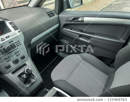 Clean and modern vehicle interior showcasing cozy seating and organized controls during a peaceful afternoon drive in the city 133469763