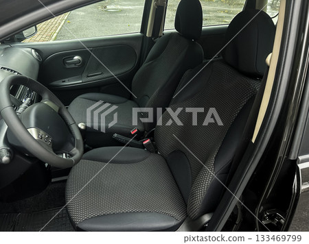 Interior of a modern car showcasing comfortable seating and clean design in a parked vehicle under natural light 133469799