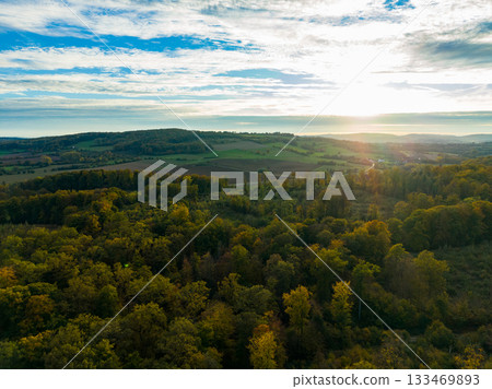 Sunrise over a serene forest landscape in autumn with vibrant colors and a peaceful morning atmosphere Sunrise over a serene forest landscape in autumn with vibrant colors and a peaceful morning atmosphere 133469893