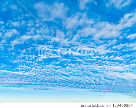 Vast blue sky adorned with fluffy white clouds during a serene afternoon, inviting moments of reflection and joy while nature unfolds Vast blue sky adorned with fluffy white clouds during a serene afternoon, inviting moments of reflection and joy while nature unfolds 133469894
