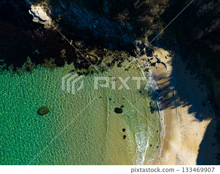 Scenic view of a tranquil beach at sunrise, capturing the crystal-clear waters and gentle waves whispering against the shore Scenic view of a tranquil beach at sunrise, capturing the crystal-clear waters and gentle waves whispering against the shore 133469907