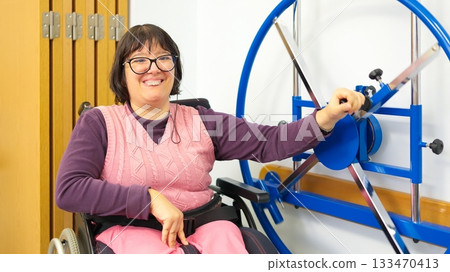 Woman smiling using shoulder wheel for rehabilitation therapy Woman smiling using shoulder wheel for rehabilitation therapy 133470413