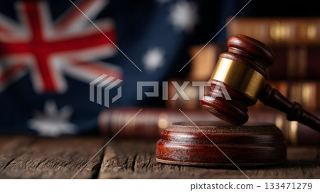 Wooden gavel striking base with law books and national flag in courtroom setting conveying legal authority and justice 133471279