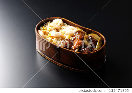 蝦仁炒飯和黑醋糖醋豬肉便當,以黑色背景拍攝。 蝦仁炒飯和黑醋糖醋豬肉便當,以黑色背景拍攝。 133471805