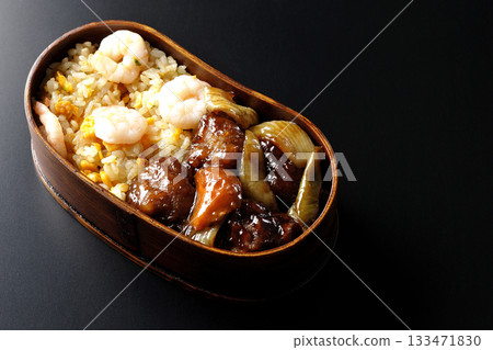 Shrimp fried rice and black vinegar sweet and sour pork bento photographed against a black background Shrimp fried rice and black vinegar sweet and sour pork bento photographed against a black background 133471830