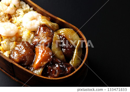 蝦仁炒飯和黑醋糖醋豬肉便當，以黑色背景拍攝。 133471833
