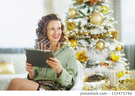 Relaxed Woman Using Tablet by Christmas Tree Relaxed Woman Using Tablet by Christmas Tree 133473740