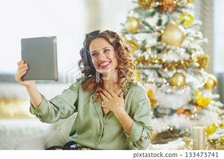 Smiling Woman Sharing Virtual Holiday Cheer Smiling Woman Sharing Virtual Holiday Cheer 133473741