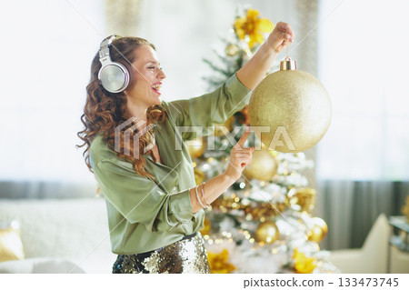Smiling Woman with Headphones Dancing at Christmas Smiling Woman with Headphones Dancing at Christmas 133473745