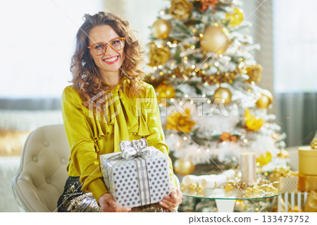Woman with Gift Box in Festive Christmas Armchair 133473752