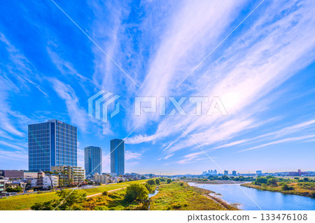 Tokyo cityscape, Japan, November 24th. Early morning view of the Tama River, its sparkling waters, and the tower apartment complexes in front of Musashi-Kosugi Station. Tokyo cityscape, Japan, November 24th. Early morning view of the Tama River, its sparkling waters, and the tower apartment complexes in front of Musashi-Kosugi Station. 133476108