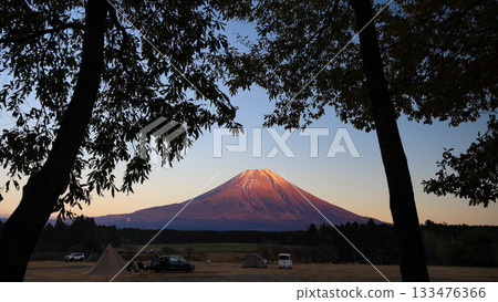 A spectacular view of Mount Fuji dyed red by the setting sun from a campsite on the Asagiri Plateau at the foot of Mount Fuji in late autumn. Fujinomiya City, Shizuoka Prefecture, Japan 133476366