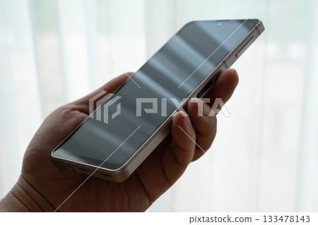 一名男子在黑暗中拿著智慧型手機——疑似詐騙圖片 一名男子在黑暗中拿著智慧型手機——疑似詐騙圖片 133478143