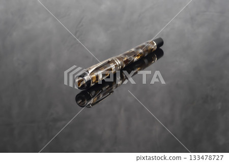 A branded fountain pen next to a box. Gift set. Selective focus. Office interior 133478727