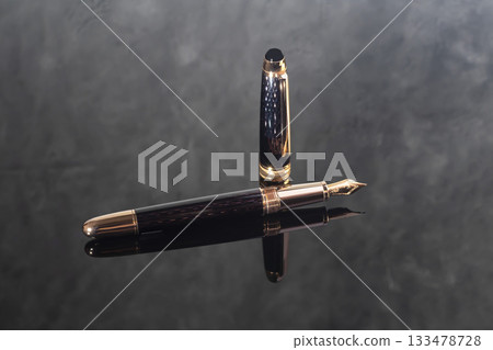 A branded fountain pen next to a box. Gift set. Selective focus. Office interior 133478728