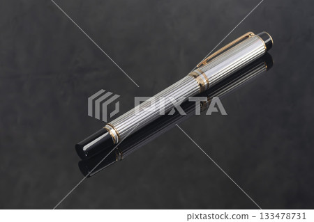 A branded fountain pen next to a box. Gift set. Selective focus. Office interior 133478731